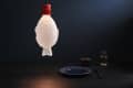 Fish-shaped pendant light with red cap above a dark table set with a blue plate, chopsticks, and a glass.