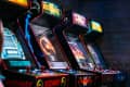 Row of vintage arcade machines featuring Mortal Kombat in a dimly lit room.