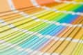 Fan of colorful paint swatches arranged in a gradient spectrum.