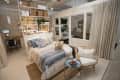Cozy bedroom with a blue and white bedspread, wicker chair, small desk, and open shelving with baskets and plants.