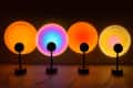 Four lamps projecting circles in sunset colors on wall