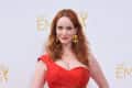 Christina Hendricks in a red dress with gold earrings at the 66th Emmy Awards.