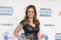 Person in a sequined dress at the American Giving Awards event backdrop.