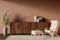 Cozy living space featuring a wooden sideboard, beige armchair with ottoman, decorative vases, and a tall plant.
