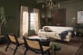 Olive hued living room with light colored sofa and caned accent chairs.
