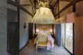 Fairy-tale themed bedroom with a large dress canopy, ornate pink headboard, tufted yellow sofa, and balcony view.