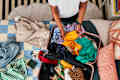 shot of someone folding clothes in a suitcase