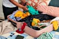 shot of someone folding clothes in a suitcase.