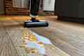 cereal and milk spill on wood floor with wet vacuum in background
