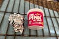 An oven rack under The pink Stuff cleaning paste next to a ball of aluminum foil.