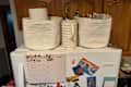 White rope storage baskets storing kitchen goods on top of refrigerator.