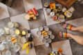 organized piles labeled with orange sticky notes, grey and white tile diamond pattern floor, rainbow sandles