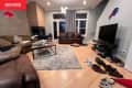 Messy living room with leather sofas around.