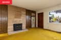 Mustard carpet in vintage wood paneled living room.