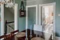 green-blue dining room with 2 doors leading to the kitchen