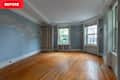 Empty room with light blue walls featuring cloud patterns, hardwood floor, and a white bookshelf.