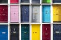 A collage of colorful doors in various shades, including red, green, blue, yellow, and gray, arranged in a grid pattern.