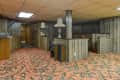 Retro basement with wood paneling, floral carpet, and vintage lamp.