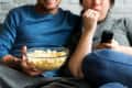 couple watching tv with popcorn