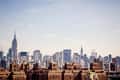 New York City skyline with Empire State Building and Chrysler Building under a clear sky.