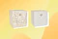Two storage cubes, one with floral pattern and one plain, each featuring a circular metal handle.