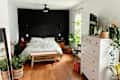 A white bedroom with a black accent wall