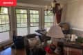 Photo of room before transformation into home office: room is full of decor items, boxes, bags
