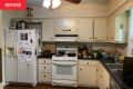 Dark lighting and cream colored painted cabinets in kitchen before renovation.