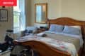 Wooden bed frame in bedroom before renovation.