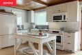kitchen before remodel: white cabinets, drawers, counters, kitchen island, wood ceiling, accents