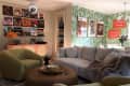 Records hung on picture ledge above sideboard in living room with seating and disco ball.