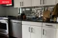 Knives on magnetic strip in kitchen before applying peel and stick backsplash.