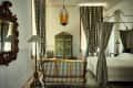 Green hotel room with wardrobe painted in trompe l'oeil style