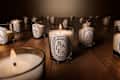 Diptyque candle collection on wooden table.