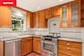 Kitchen with wooden cabinets, stainless steel dishwasher, gas stove, and white subway tile backsplash.