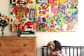Shana Blakley iheirloom collage of kids' art on the wall with a young girl hugging a dog in the foreground