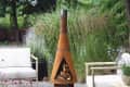 outdoor space with fire pit chimney and two chairs