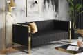 Black sofa with gold frame, marble wall art, gold floor lamp, and green plant in a modern living room.