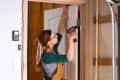 Woman drilling door hinge
