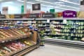 Grocery store produce section with fresh fruits, vegetables, and organic packaged salads on display.