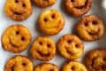 Smiley face potato fries on a paper towel-lined tray.