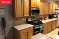 brown and gray kitchen with wood cabinets before renovation