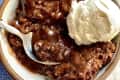 Chocolate cobbler in bowl with scoop of vanilla ice cream