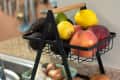 2 tiered fruit and vegetable stand full of fruits and vegetables on counter