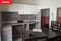 White cabinets in kitchen with grey countertops and backsplash before renovation.