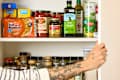 head on shot of an assortment of spices and other pantry items in a kitchen cabinet.