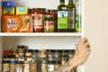 head on shot of an assortment of spices and other pantry items in a kitchen cabinet.