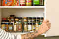 head on shot of an assortment of spices and other pantry items in a kitchen cabinet.