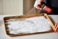 Spraying hydrogen peroxide on a baking sheet covered with baking soda.