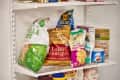 Assorted snack bags and pantry items on white wire shelving, including chips and brown sugar.